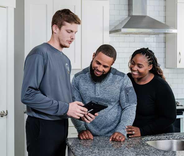 mover showing a couple standing next to him something on a tablet
