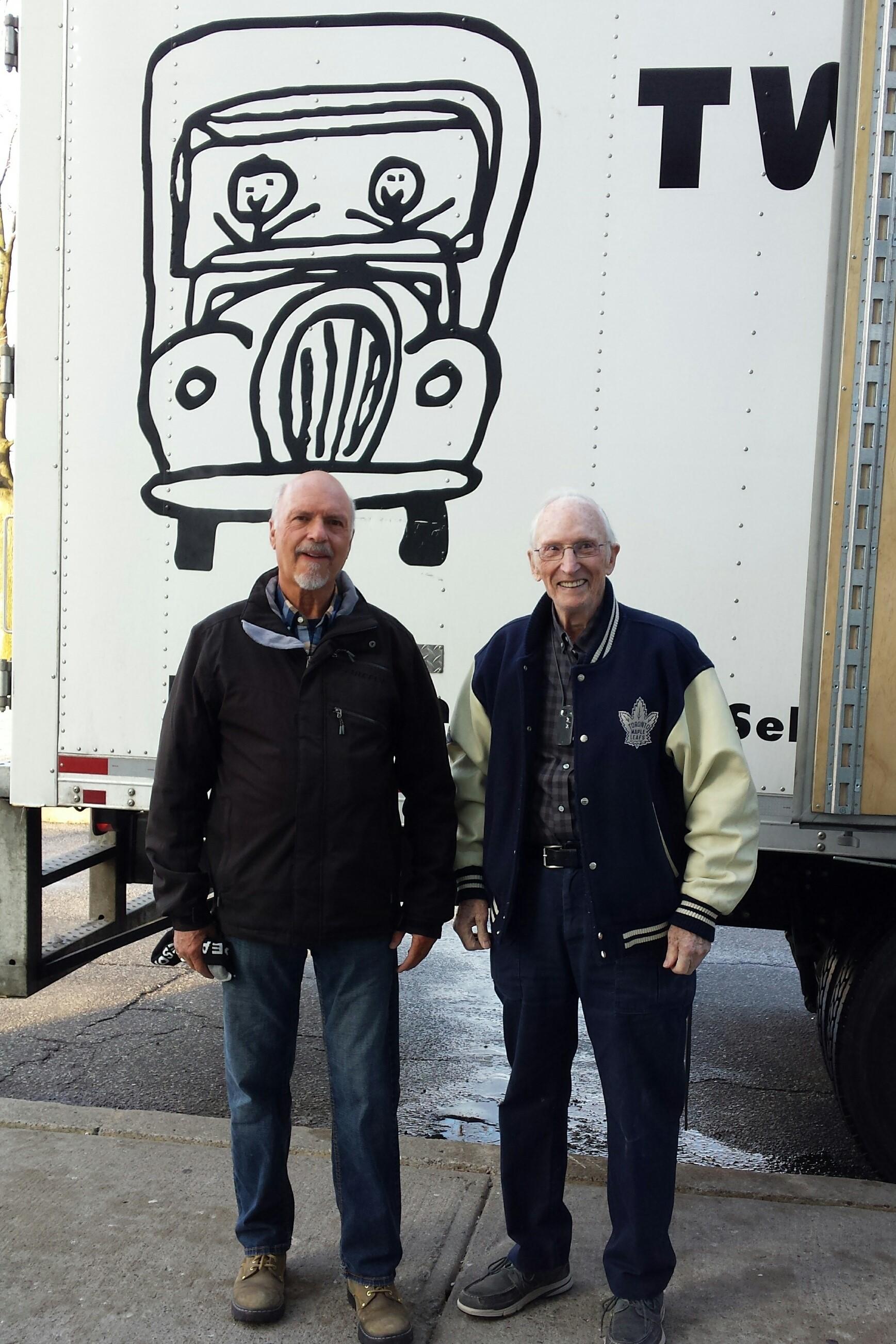 two men and a truck parked in front of atalla house