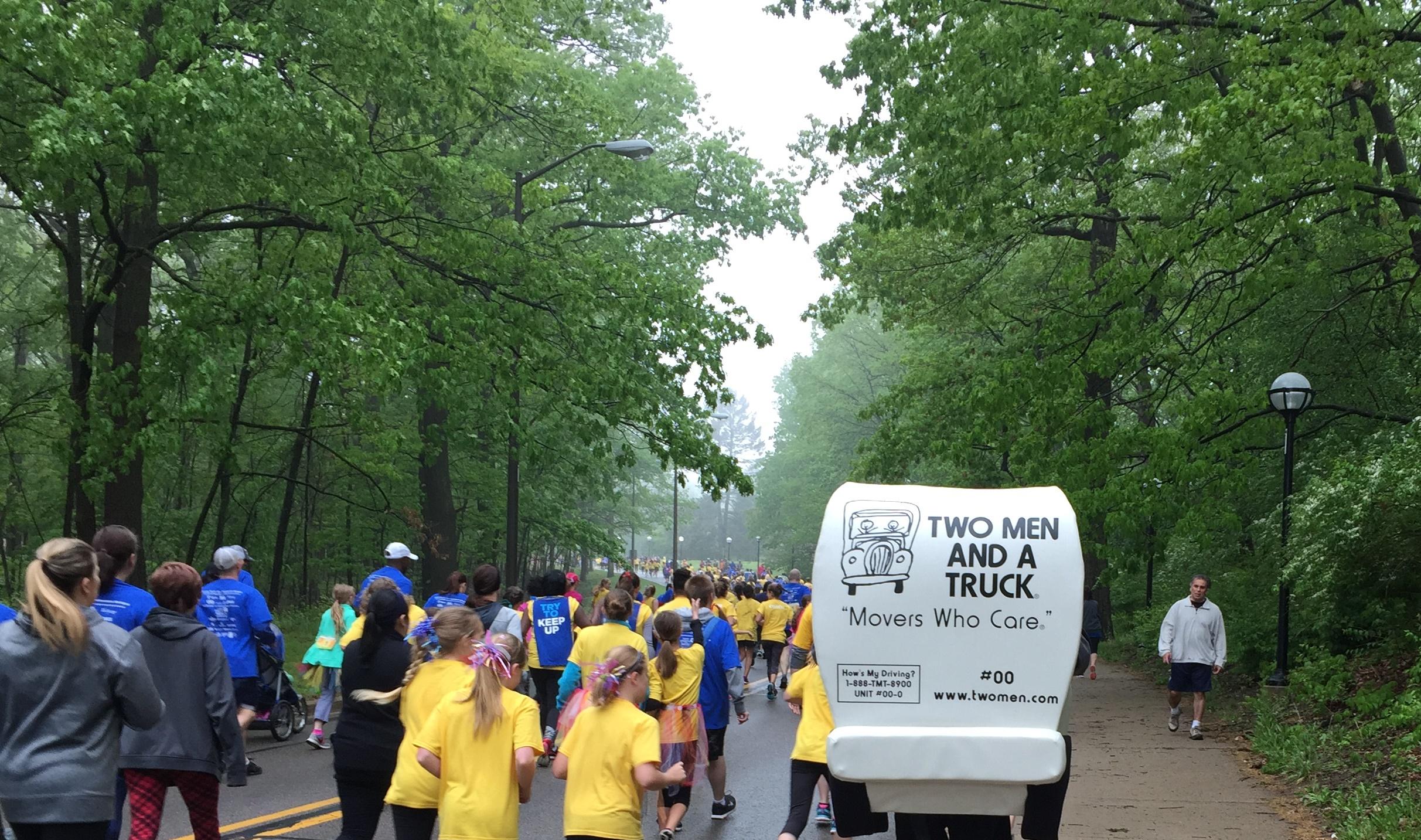 Truckie mascot is running alongside the participants of the Girls on the Run 5K