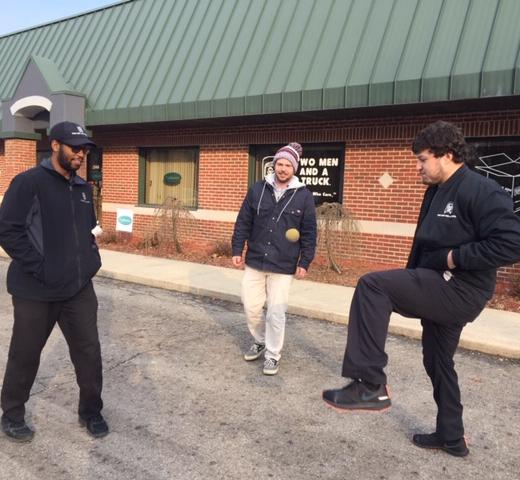 3 men playing hackey sack after work