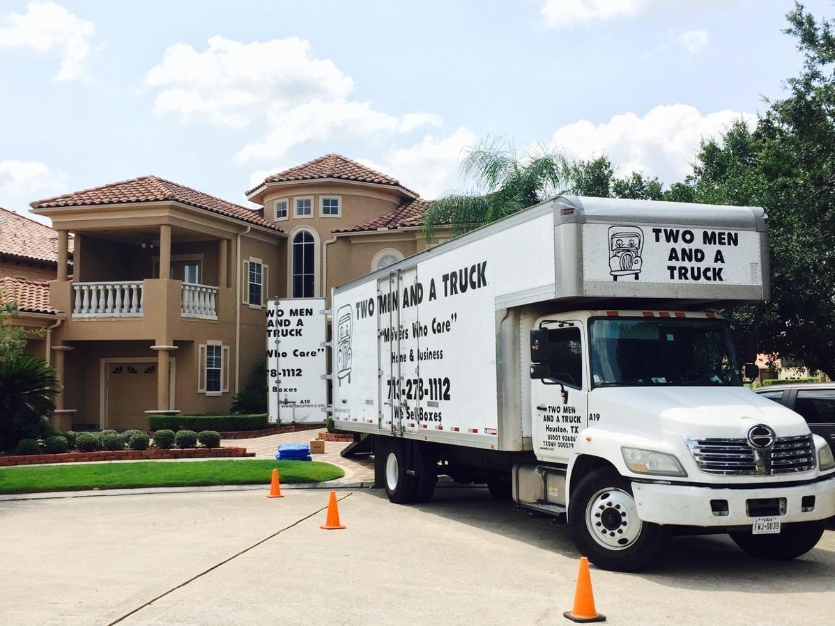 two men and a truck parked in front of atalla house