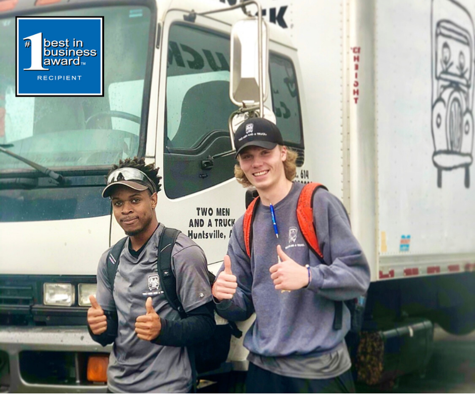 Huntsville movers, Tommy and Jacob, smile in front of a truck 
