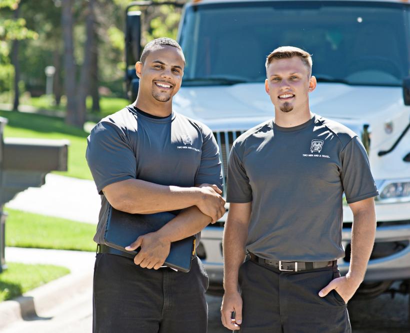 TWO MEN AND A TRUCK Mover and Driver Team standing with the truck behind them. 