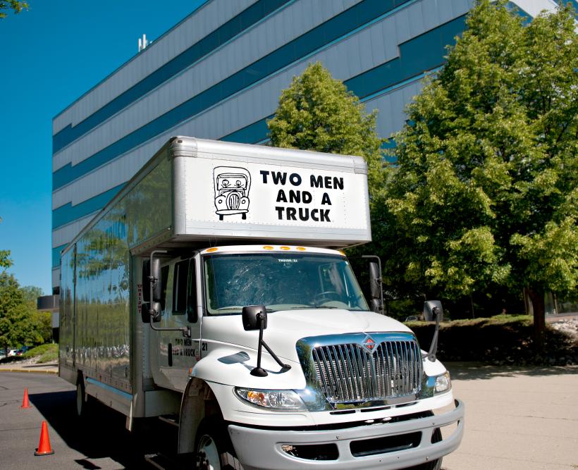 Moving truck parked in front of an office building.