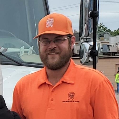 Two employees in front of moving truck with Truckie mascot.
