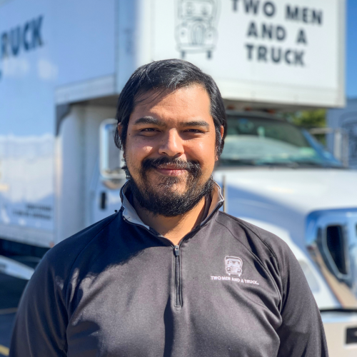 David Navarrette standing in front of TWO MEN AND A TRUCK moving truck