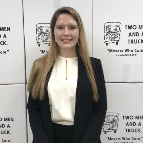 Elizabeth Nabejar standing in front of TWO MEN AND A TRUCK moving boxes