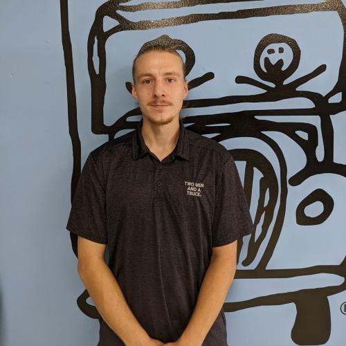 will standing in front of a blue wall with the two men and a truck logo