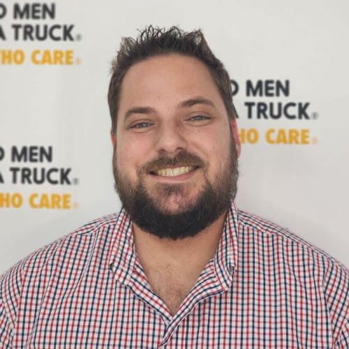 scott standing in front of TWO MEN AND A TRUCK logos