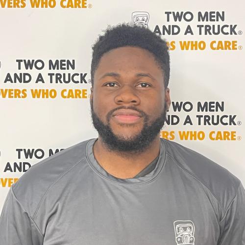 O&#039;Neil standing in front of two men and a truck logo