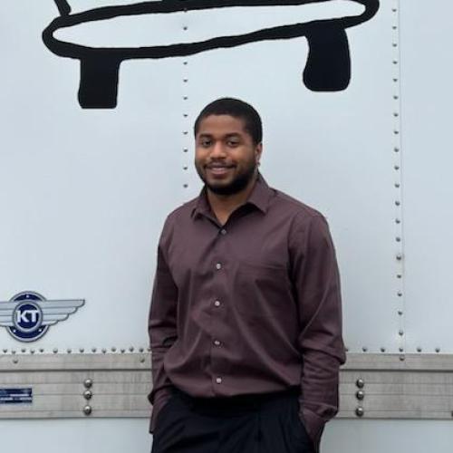 Adrian posed in front of logo