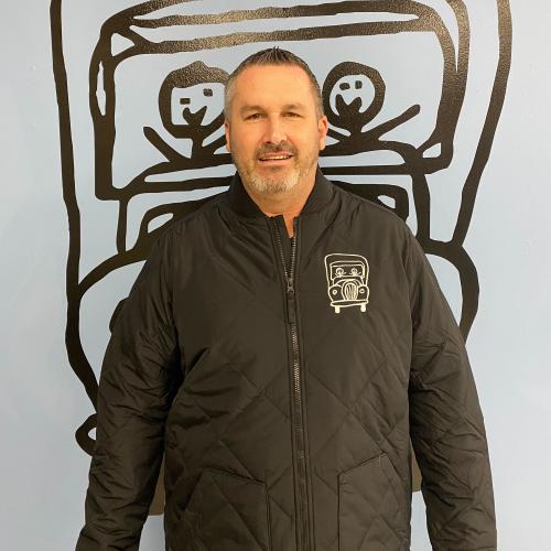 craig is standing in front of a blue wall with the truckie logo