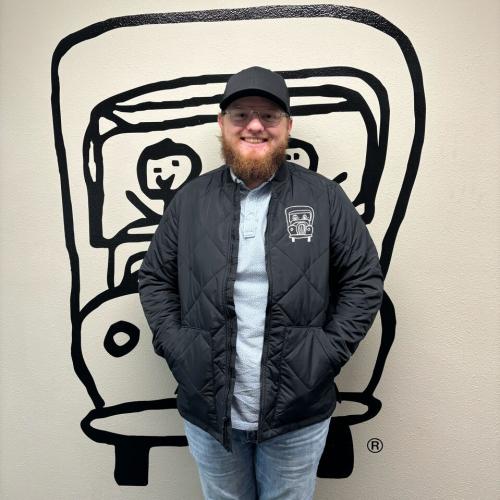 nick is standing in front of a wall with the two men and a truck logo behind him