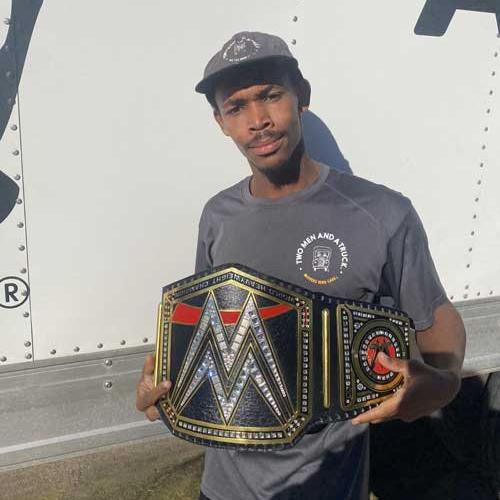 Jalen - mover of the month at two men and a truck holding a championship belt