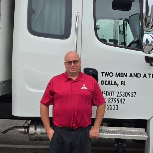 Man standing beside moving truck