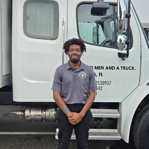 Man standing beside moving truck