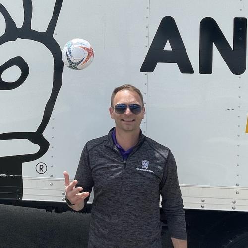 Soccer ball in front of moving truck. 