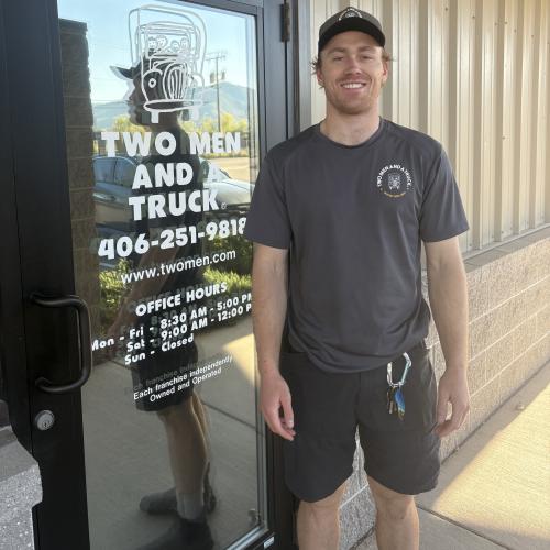 Jack standing in front of two men and a truck door