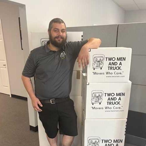 Chris - Move manager with two men and a truck leaning on boxes