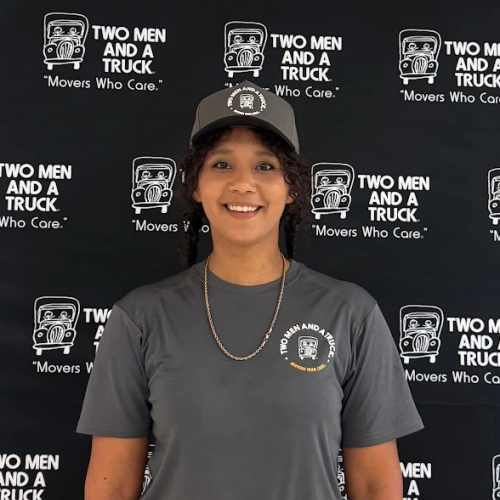 a young girl with a hat on in front of a branded backdrop