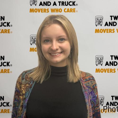 atiana wearing black shirt and multicolored coverup standing in front of two men and a truck backdrop
