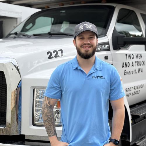 riley is standing in front of a moving truck outside