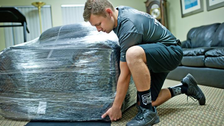 TWO MEN AND A TRUCK Mover Moving A Piece Of Furniture 