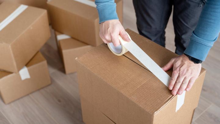 Person packing a box for their move